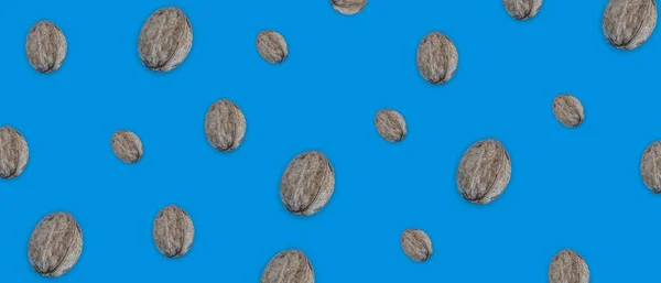 Creative food layout. Walnut on blue background top view copy space. The concept of food, healthy food, nuts, healthy fats. Walnut pattern. Organic healthy vegan snacks.