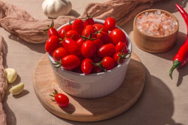 Beyaz tabakta mayalanmış kırmızı kiraz domatesleri. Vejetaryen yemeği. Tuzlu domates. Salamura organik domates. Ev yapımı mayalanmış yiyecekler. Yiyecek stokları. Sert gölge