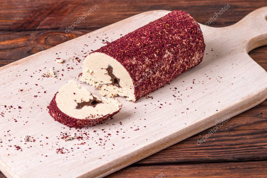 Eastern sweet halva with chocolate and rose powder on wooden background.
