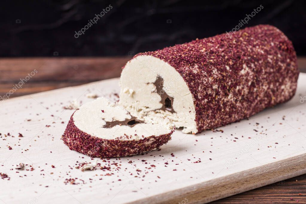 Eastern sweet halva with chocolate and rose powder on wooden background.