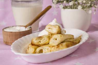 Süzme peynirli, üzümlü ve ekşi kremalı dürülmüş krep..