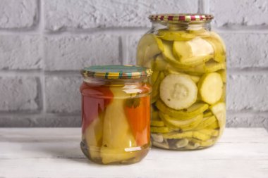 Gri bir duvara karşı ahşap arka planda kavanozlar dolusu sebze konservesi. Kış için ev yapımı sebzeler.