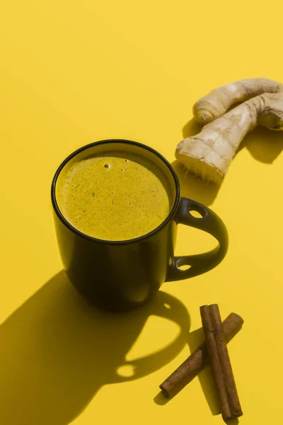 Moon milk for better sleep. Turmeric Golden Milk with Cinnamon. Ayurvedic drink. Popular drink. Golden latte on a light background. Indian drink turmeric golden milk in a cup.