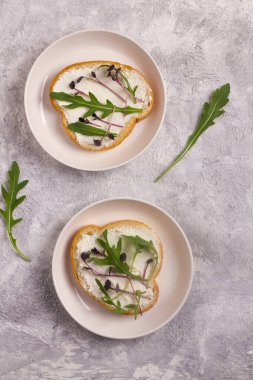 Aroaranth mikroyeşillikli iki sandviç. Mor yapraklar, saplar ve taze roka yaprakları. Vejetaryen ve sağlıklı yiyecek konsepti..