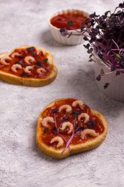 Karidesli ve amaranth mikro yeşillikli sandviç. Hafif arka planda tost ekmeği olan ev yapımı sandviç, üst manzara. Kopya alanı olan lezzetli karidesli sandviç..