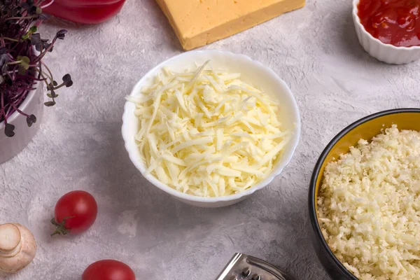 Derin tabakta rendelenmiş mozzarella peyniri. Keto pizza hamuru yapma işlemi.