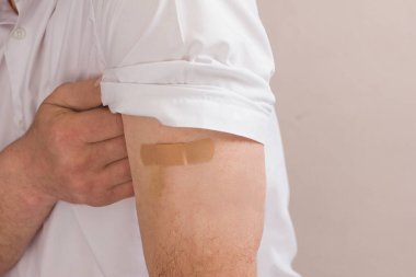 Aşıdan sonra pastel arka planda fotokopi alanı olan bir adamın portresi. Koronavirüs aşısının yapıldığı yerdeki çürüğe endişeyle bakan bir adam. Aşıdan sonra yan etkiler.