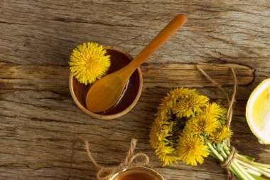 Ahşap bir masada sarı karahindiba ile ev yapımı lezzetli karahindiba reçeli. Karahindiba çiçeği şurubu. Kış için kullanışlı bir koruma.