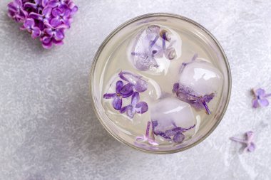 Limonatalı bardak ve leylak çiçekli buz küpleri. Üst görünüm