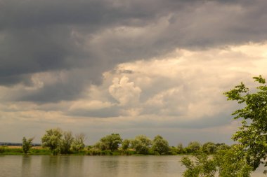 Gökyüzü yağmurdan önce bulutludur. Nehrin üstündeki gökyüzünde gri fırtına bulutları.