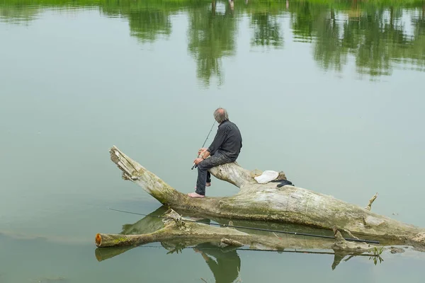 Пожилой Лысый Мужчина Рыбачит Сидя Загвозде — стоковое фото
