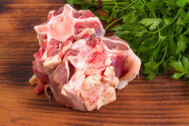 Tahta arka planda taze çiğ sığır kuyruğu parçaları..