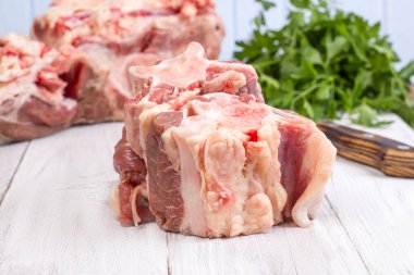 Tahta arka planda taze çiğ sığır kuyruğu parçaları..