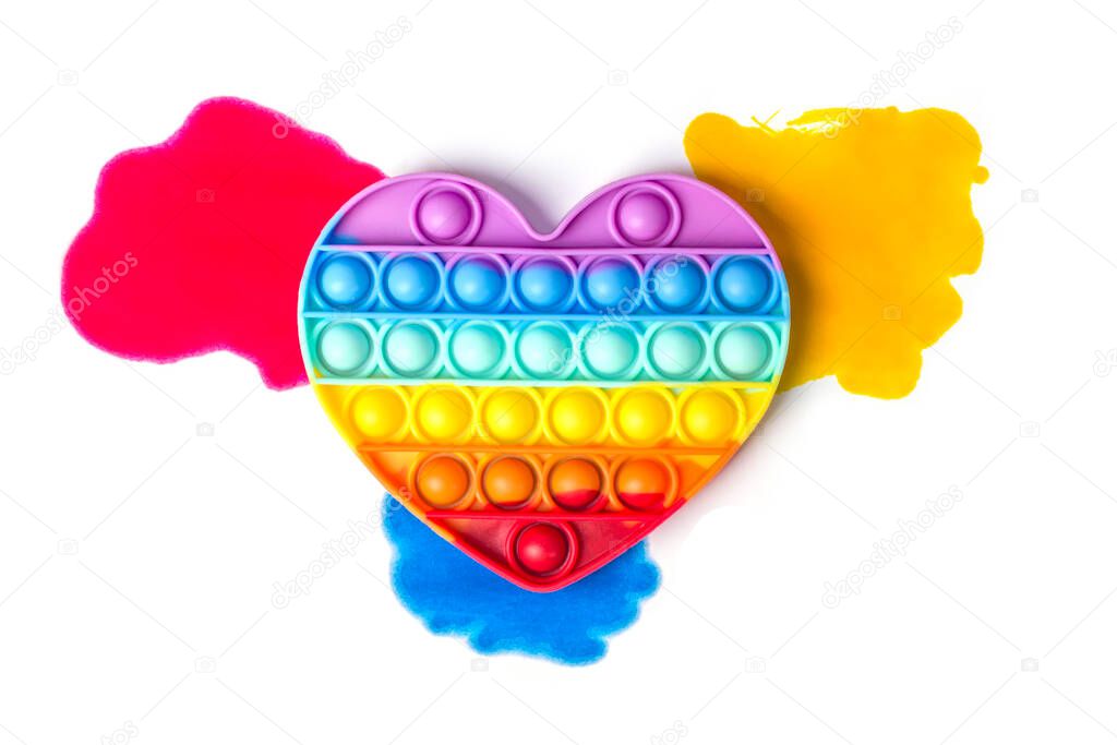 Silicone rainbow heart on bright stains of paint.