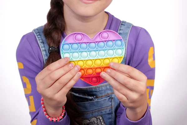 Молодая Девушка Держит Руках Силиконовое Разноцветное Сердце — стоковое фото