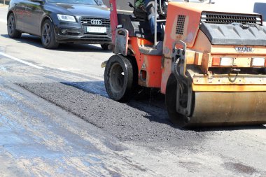 Ukrayna, Odessa, 2021 yazı. Patinaj makinesi yolu tamir ediyor. Onarım, karmaşık ulaşım hareketi