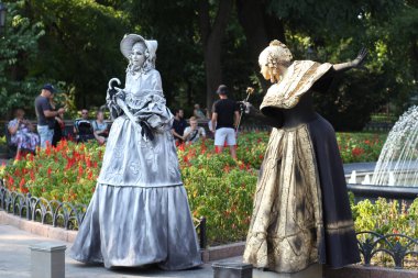 Ukrayna, Odessa, 2021 yazı. Bronz heykel gibi görünen iki kız. Canlı heykeller