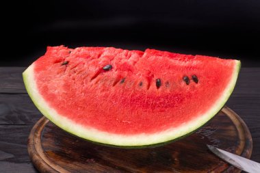 Çeyrek sulu olgun, koyu arkaplanda karpuz.
