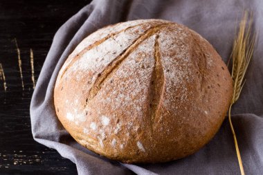 Koyu arkaplanda yuvarlak karabuğday ekmeği. Üst görünüm