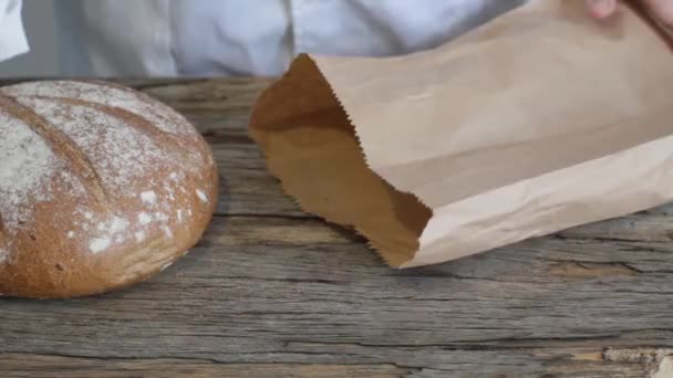 贝克把刚烤好的荞麦面包装在纸袋里 — 图库视频影像