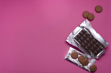 Çikolataların en üst görüntüsü, pembe yüzeyde tatlı yuvarlak kurabiyeler. Boş alan.
