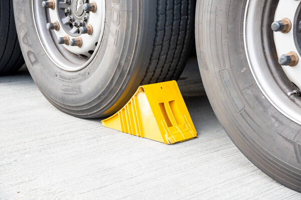 Berlin, Berlin/Germany - 15.08.2020: A yellow brake shoe in front of a truck tire photographed from the side