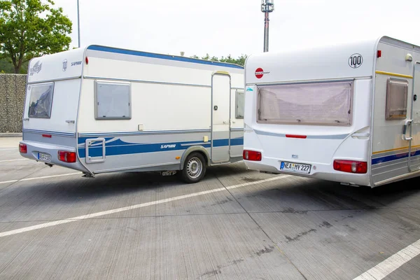 Berlin, Berlin/Germany - 15.08.2020: Two single-axle caravans parked side by side on a freeway parking lot. — Stock Image Berlin Berlin Germany 2020 Two Single Axle Caravans Parked Side Royalty Free Stock Photos