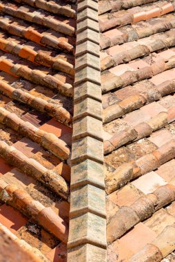 Yukarıdan fotoğraflanmış eski bir kiremit çatı, orada fayanslar çapraz olarak yukarı doğru balık desenine gidiyor. Arkaplan veya doku olarak.