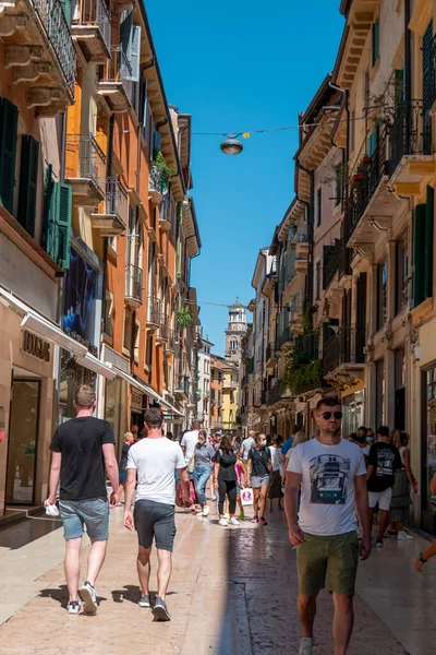 Verona, Veneto / İtalya - 18.08.2020: Covid19 salgın zamanlarında kimilerinin maske taktığı ve kimilerinin maske takmadığı Verona 'da pek çok turistin araba kullanmasına izin verilmeyen küçük bir ara sokak.