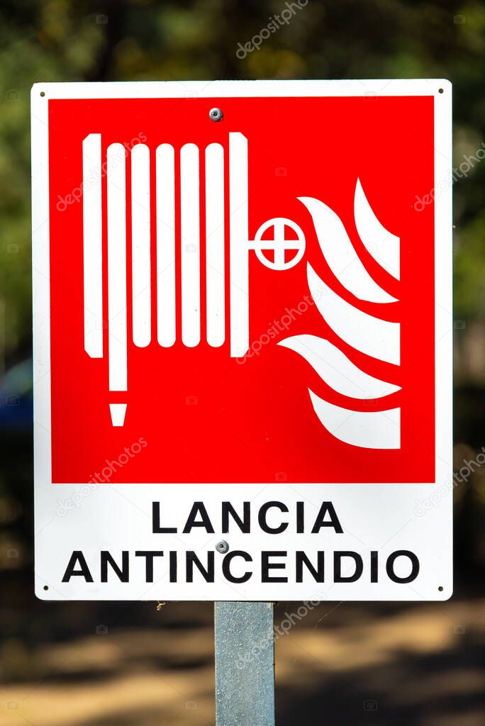 A red and white sign indicating a fire hose in Italian with the symbol for a fire and a hose that can be quickly extinguished in case of fire.