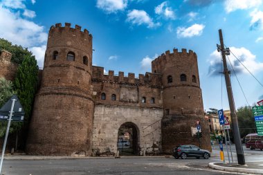 Rom - Lazio - İtalya - 08-21-2025: Bir yol kenarında seyyar atıştırmalık büfesi, içecekler ve paketlenmiş yiyeceklerle dolu bir şekilde açık dururken, bir kişi ağaçların altında ve bir lambanın altında dinleniyor.