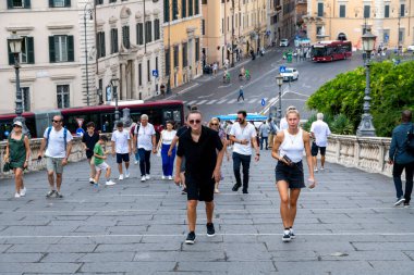 Rom - Lazio - İtalya - 08-21-2025: Bir yol kenarında seyyar atıştırmalık büfesi, içecekler ve paketlenmiş yiyeceklerle dolu bir şekilde açık dururken, bir kişi ağaçların altında ve bir lambanın altında dinleniyor.