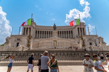 Rom - Lazio - İtalya - 08-21-2025: Bir yol kenarında seyyar atıştırmalık büfesi, içecekler ve paketlenmiş yiyeceklerle dolu bir şekilde açık dururken, bir kişi ağaçların altında ve bir lambanın altında dinleniyor.