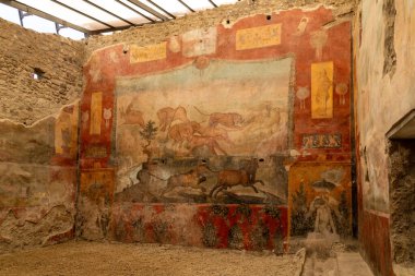 Pompei - Campania İtalya 08-25-2025: Turistler Pompei antik amfitiyatrosunun taş basamaklarını keşfederken, gruplar açık gökyüzü ve uzak dağlar altında arenada bir araya geldiler.
