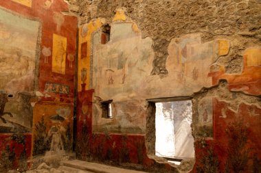 Pompei - Campania İtalya 08-25-2025: Turistler Pompei antik amfitiyatrosunun taş basamaklarını keşfederken, gruplar açık gökyüzü ve uzak dağlar altında arenada bir araya geldiler.