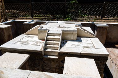 Pompei - Campania İtalya 08-25-2025: Turistler Pompei antik amfitiyatrosunun taş basamaklarını keşfederken, gruplar açık gökyüzü ve uzak dağlar altında arenada bir araya geldiler.