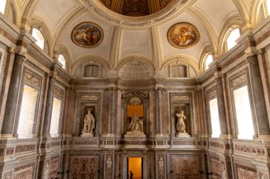 Reggia di Caserta - Campania - İtalya - 08-30-2025: Heykeller ve mermer duvarlar, Caserta Kraliyet Sarayı 'nın giriş alanı içinde yuvarlak fresklerle çevrili bir kubbe..