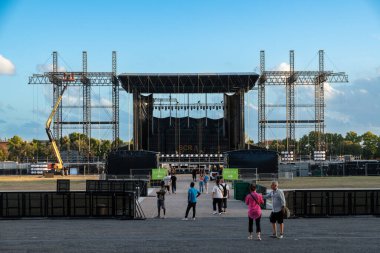 Reggia di Caserta - Campania - İtalya - 08-30-2025: Caserta Kraliyet Sarayı açık hava konser sahnesi iskelesi, vinç ve alacakaranlıkta yürüyen insanlar.