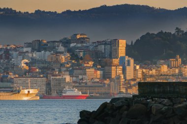 Gün batımında Vigo şehrinin manzarası körfezin diğer tarafındaki bir rıhtımdan.
