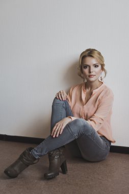 Bir kız bir beyaz duvara 5270 oturuyor.