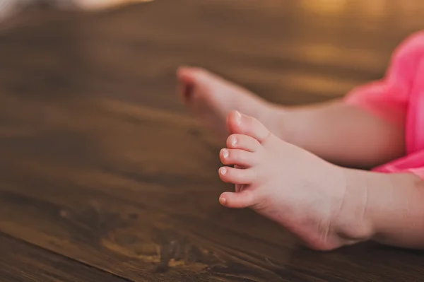 Baby feet on a wooden floor 5381. — Stock Photo, Image