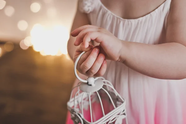 The child holds in his hand a white cage for birds 5372. — Stock Photo, Image