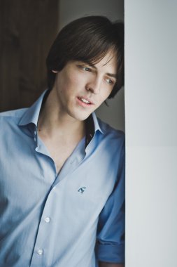 Sersem duvara yaslanmış pencere bakarak adam