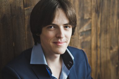 Genç bir adam ahşap duvar 5445 bir arka plan üzerinde duruyor.