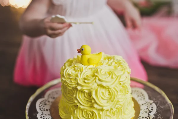 Das Mädchen schmeckt den Kuchen an ihrem ersten Geburtstag 5407. — Stockfoto