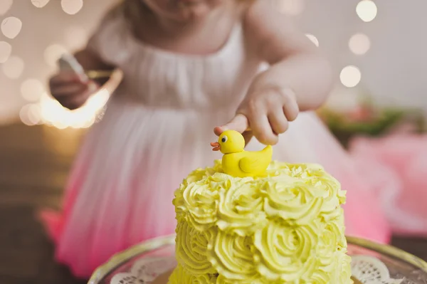 Das Mädchen schmeckt den Kuchen an ihrem ersten Geburtstag 5409. — Stockfoto