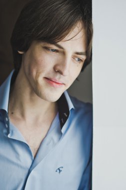 Sersem duvara yaslanmış pencere bakarak adam