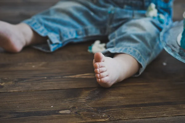 Bare foot kid standing on a wooden floor 5591. Stock Photo