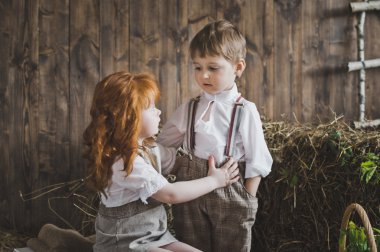 Ahşap duvarlar ve saman arka plan üzerinde elele çocuk