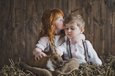 Kızıl saçlı kız ve erkek saman 6123 tavşan oynuyor.